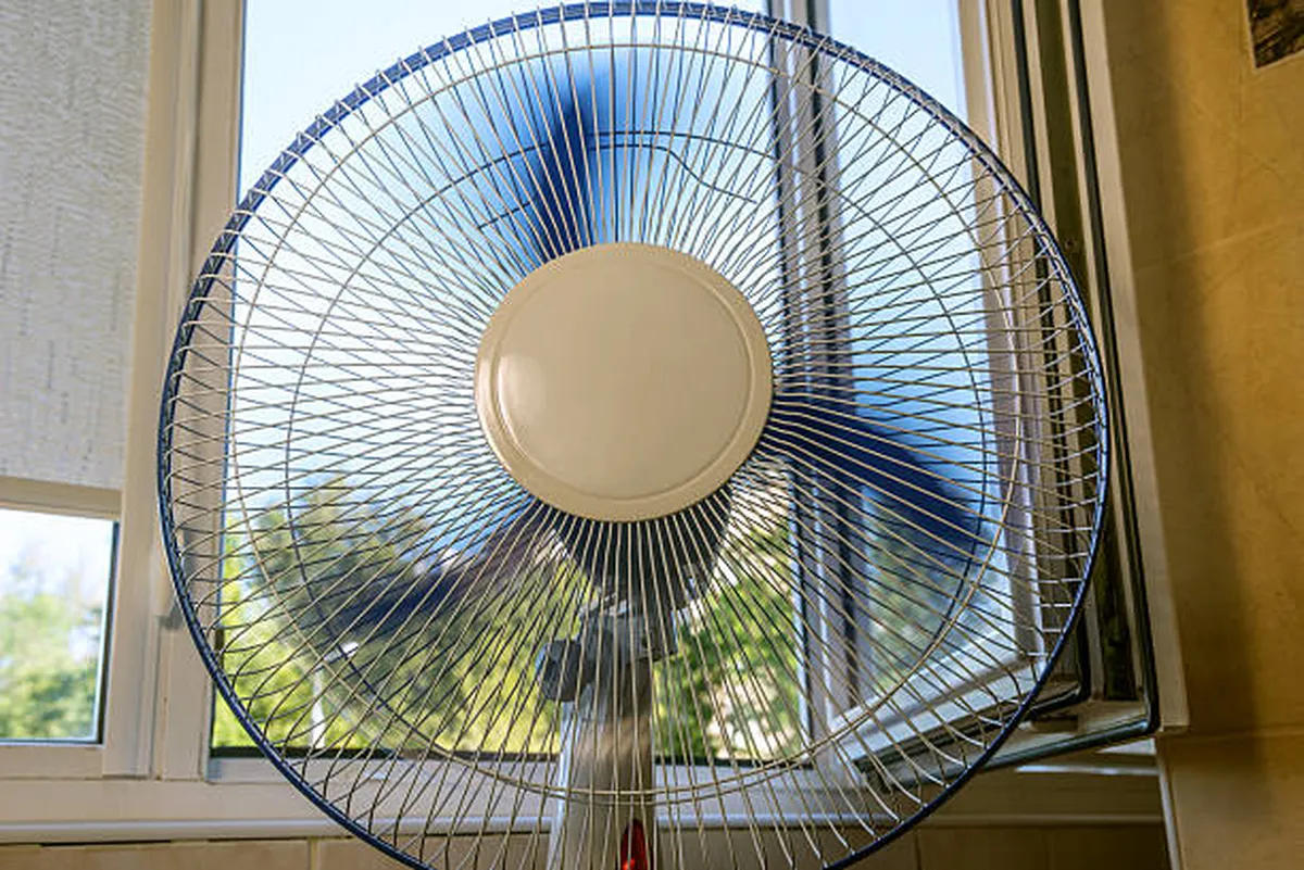  Ventilador posicionado em frente a uma janela para otimizar a circulação do ar.