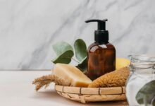 Frasco de shampoo caseiro em embalagem âmbar com ingredientes naturais ao redor.