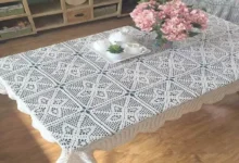 Toalha de mesa em crochê branca decorando um ambiente elegante com flores e porcelana