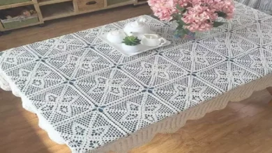 Toalha de mesa em crochê branca decorando um ambiente elegante com flores e porcelana