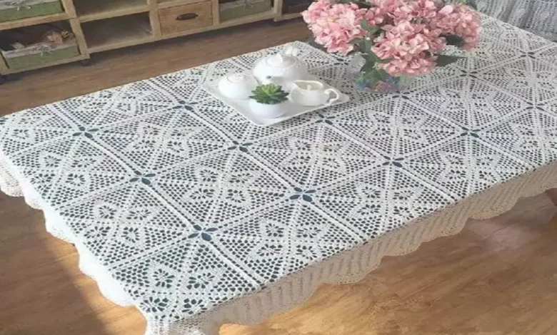 Toalha de mesa em crochê branca decorando um ambiente elegante com flores e porcelana