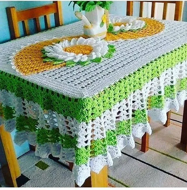 Toalha de mesa de crochê com detalhes florais em amarelo, verde e branco, trazendo um toque vibrante à decoração