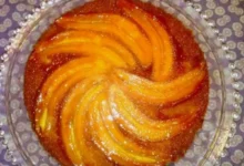 Torta de banana caramelizada servida em prato de vidro decorado.