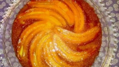 Torta de banana caramelizada servida em prato de vidro decorado.