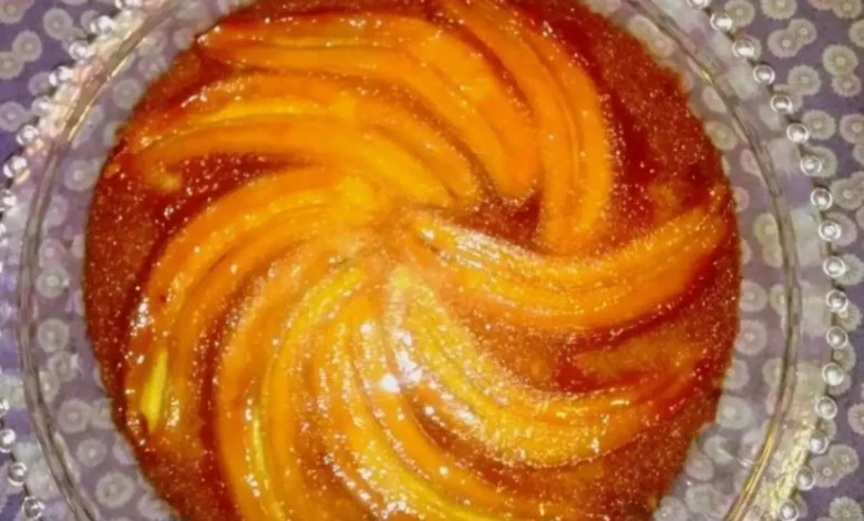 Torta de banana caramelizada servida em prato de vidro decorado.