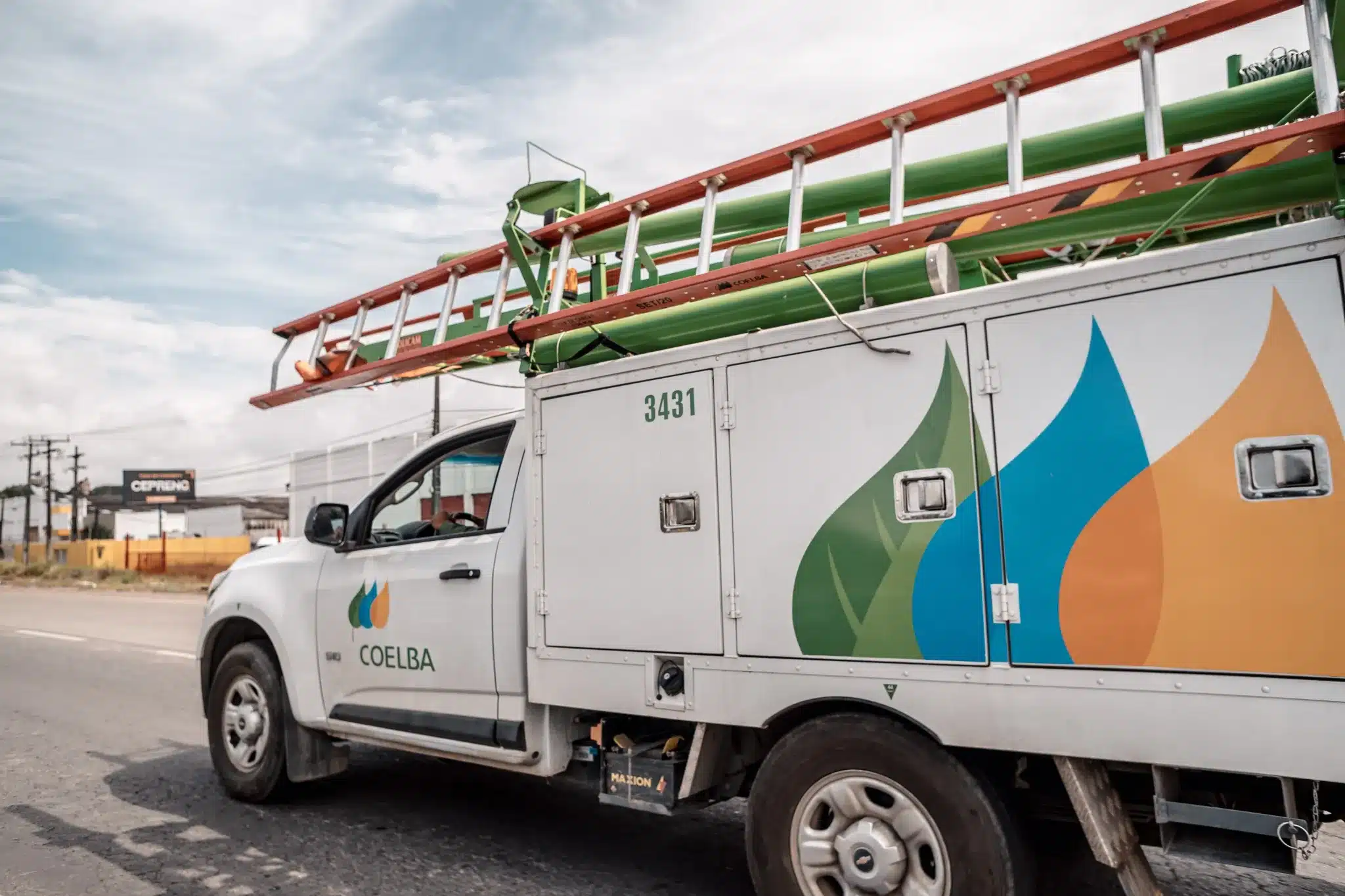Veículo da Coelba com escada e equipamentos para manutenção elétrica.