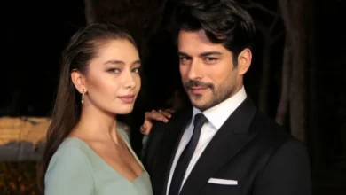 Casal de uma série turca, vestidos elegantemente, posando para uma foto promocional.