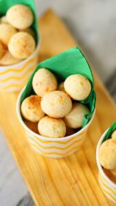  Pequenos pães de tapioca servidos em copos descartáveis, prontos para consumo.