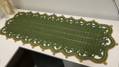 Caminho de mesa de crochê verde com acabamento dourado, trazendo sofisticação e requinte para a decoração da casa.