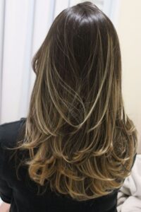 Cabelo longo em camadas visto de costas, com movimento e volume.