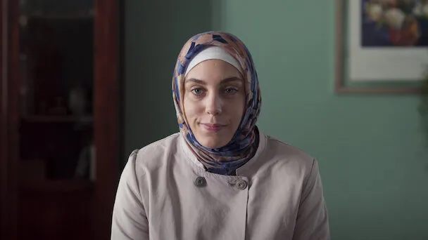 Cena da série '8 em Istambul', mostrando uma das personagens principais com um lenço, representando a diversidade e os desafios da sociedade moderna.