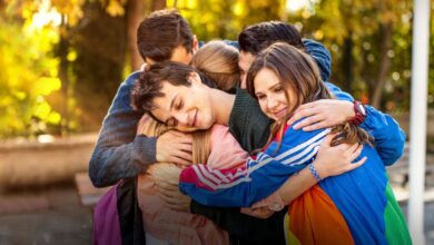 Grupo de amigos abraçados da novela turca Love 101, com uma atmosfera de amizade e afeto entre os personagens.