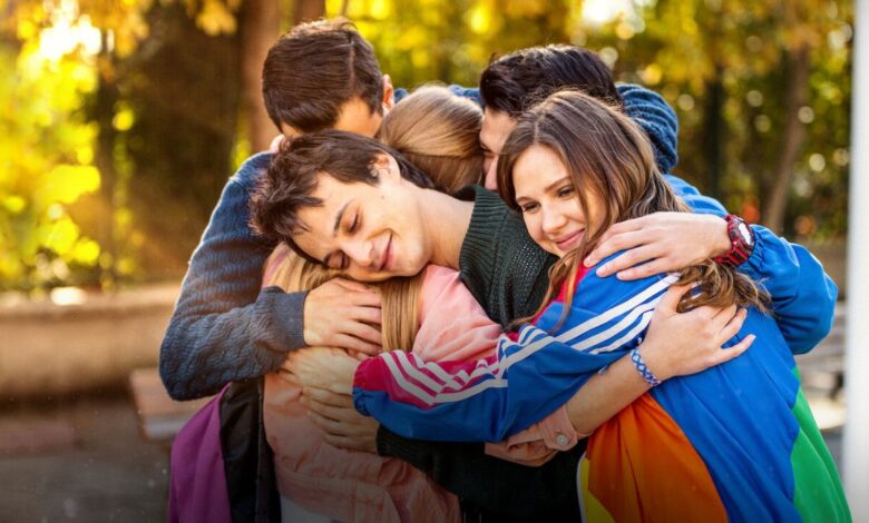 Grupo de amigos abraçados da novela turca Love 101, com uma atmosfera de amizade e afeto entre os personagens.