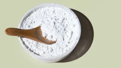 Imagem de bicarbonato de sódio em um recipiente com uma colher de madeira, ideal para limpeza de fogão, forno e geladeira.