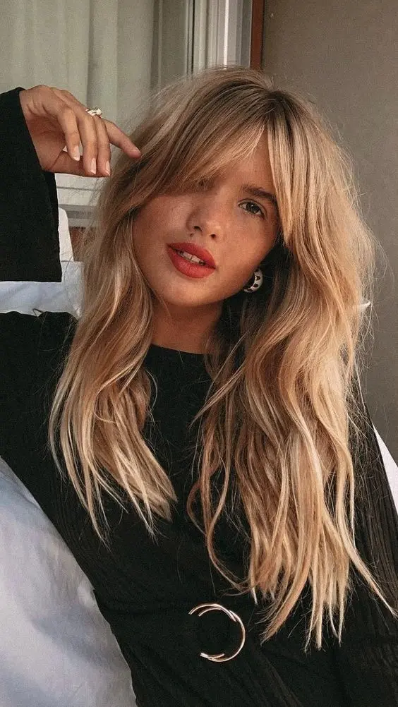 Cabelo longo com franja cortina, criando um visual moderno e descomplicado