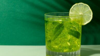 Copo de caipirinha verde com limão e folhas de hortelã, símbolo de uma caipirinha bem feita.