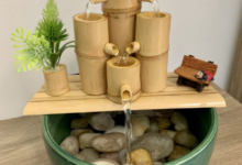 Fonte de bambu com água fluindo e plantinha decorativa.