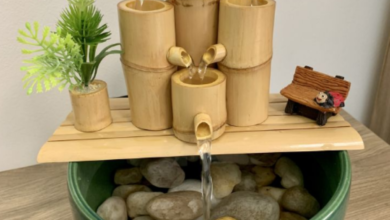 Fonte de bambu com água fluindo e plantinha decorativa.