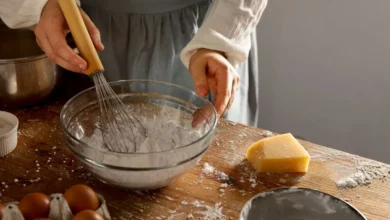 Imagem de uma pessoa mexendo ingredientes secos em uma tigela, ilustrando a preparação de receitas com bicarbonato de sódio e fermento em pó.