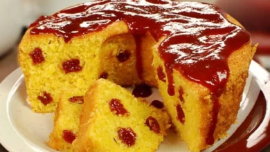 Bolo de fubá macio com pedaços de goiabada e cobertura cremosa, servido em um prato.