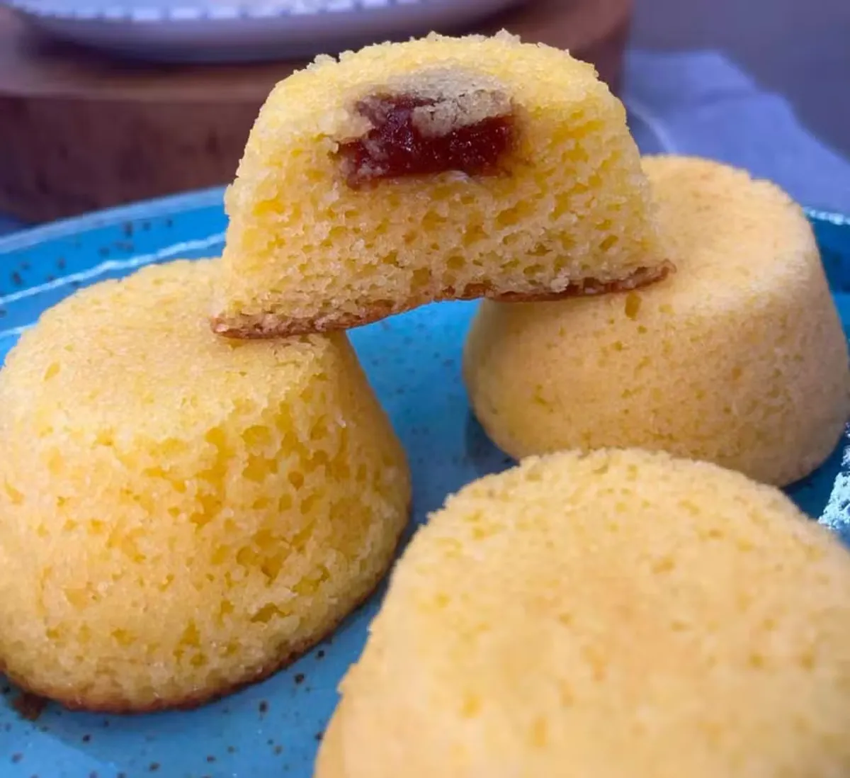 Mini bolo de fubá escaldado com recheio de goiabada servido em um prato azul.