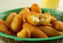 Bolinho de mandioca crocante recheado com queijo, servido em uma tigela.