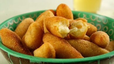 Bolinho de mandioca crocante recheado com queijo, servido em uma tigela.