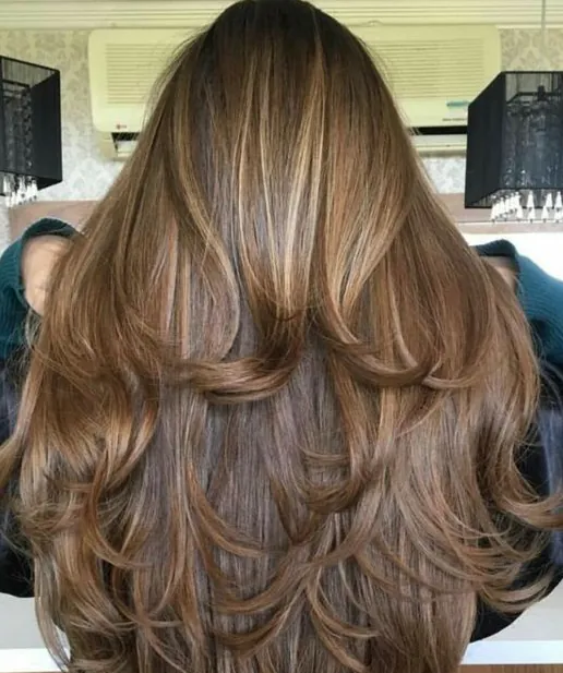 Cabelo longo repicado com nuances loiras e castanhas.