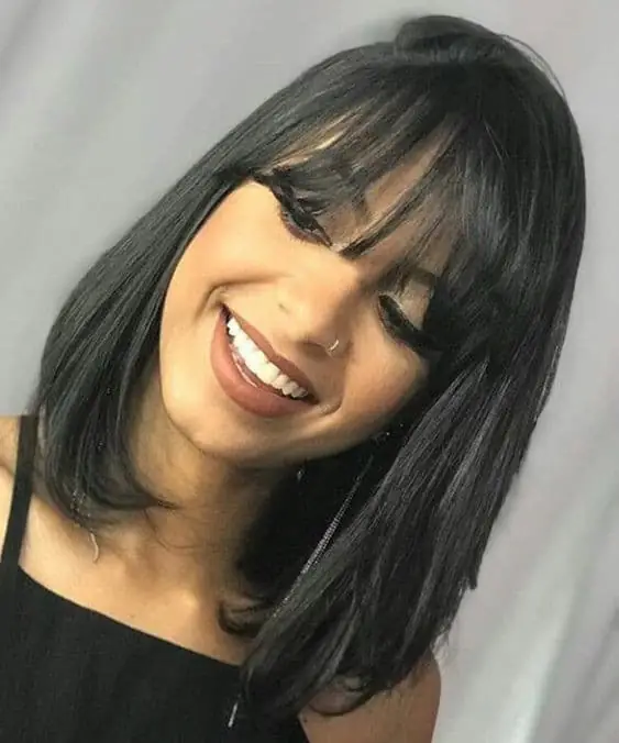 Modelo de corte chanel com bico e franja, com cabelo liso e moderno.
