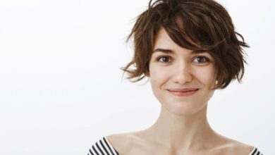 Mulher sorrindo com cabelo curto e moderno, transmitindo leveza e estilo.