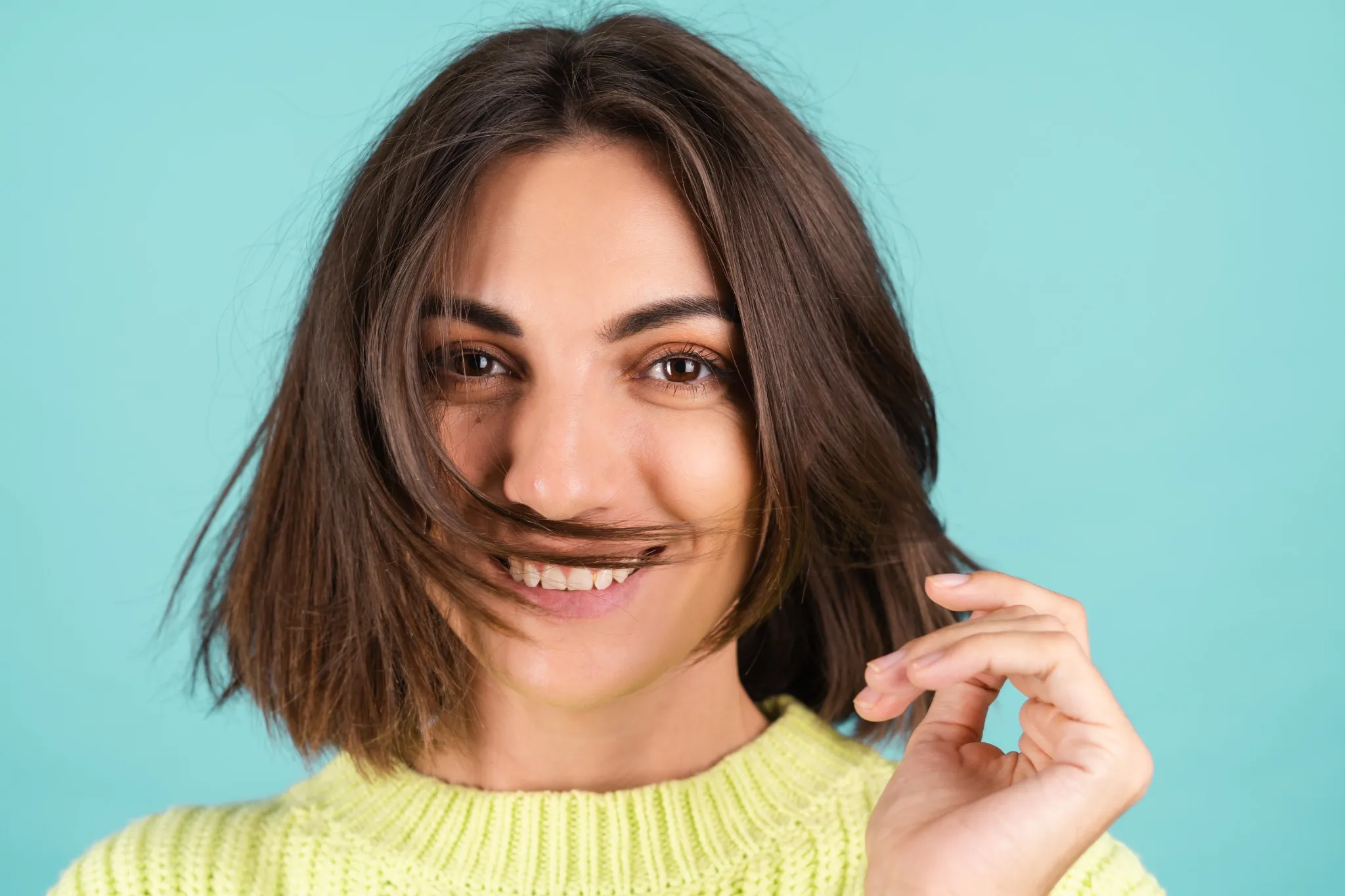 Mulher com corte médio e repicado, ideal para dar volume aos cabelos finos.