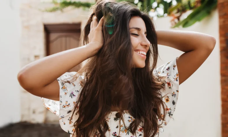 Mulher sorrindo com cabelo longo e volumoso, corte fácil de manter.