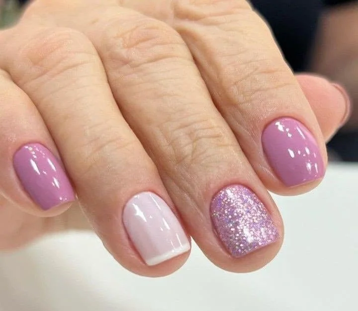 Unhas francesinhas em tons de roxo com um toque de brilho.