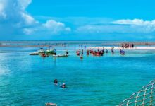 Pessoas aproveitando a beleza natural de Porto Seguro, na Bahia, com águas cristalinas e um cenário paradisíaco.