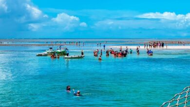 Pessoas aproveitando a beleza natural de Porto Seguro, na Bahia, com águas cristalinas e um cenário paradisíaco.