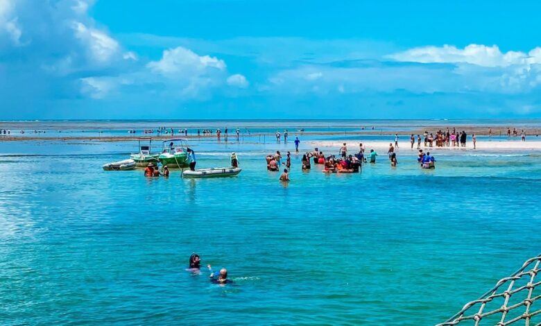 Pessoas aproveitando a beleza natural de Porto Seguro, na Bahia, com águas cristalinas e um cenário paradisíaco.