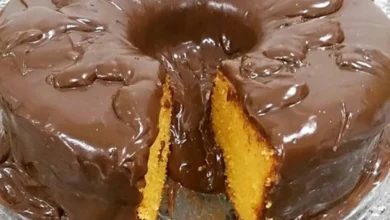 Bolo de cenoura com calda de chocolate crocante, mostrando uma fatia com a textura macia do interior.