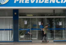 Agência do INSS com pessoas saindo e entrando no local, ilustrando os pagamentos do INSS em março de 2025.
