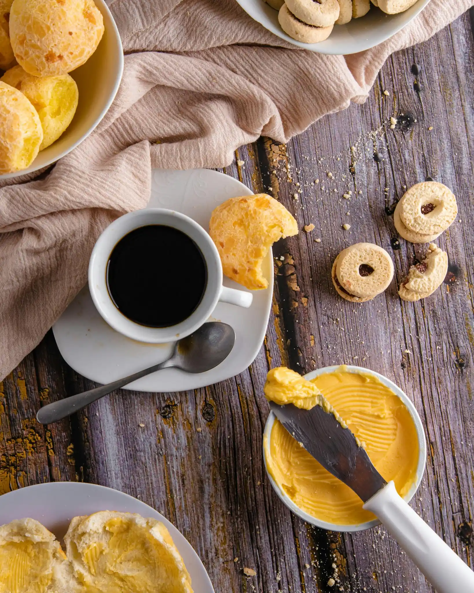 Pão de queijo crocante por fora e macio por dentro, acompanhado de café, ideal para aprender os segredos da receita.