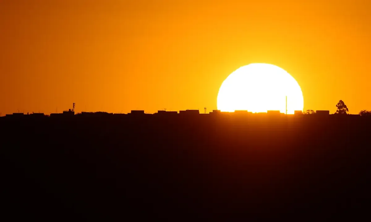 Pôr do sol iluminando o horizonte, representando o fim de semana e momentos de descanso.