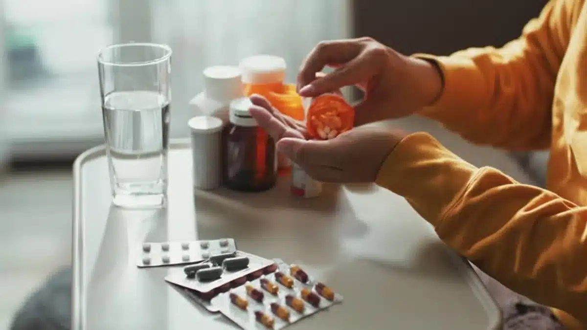 Pessoa manipulando medicamentos, com atenção para os remédios que podem afetar a pressão arterial