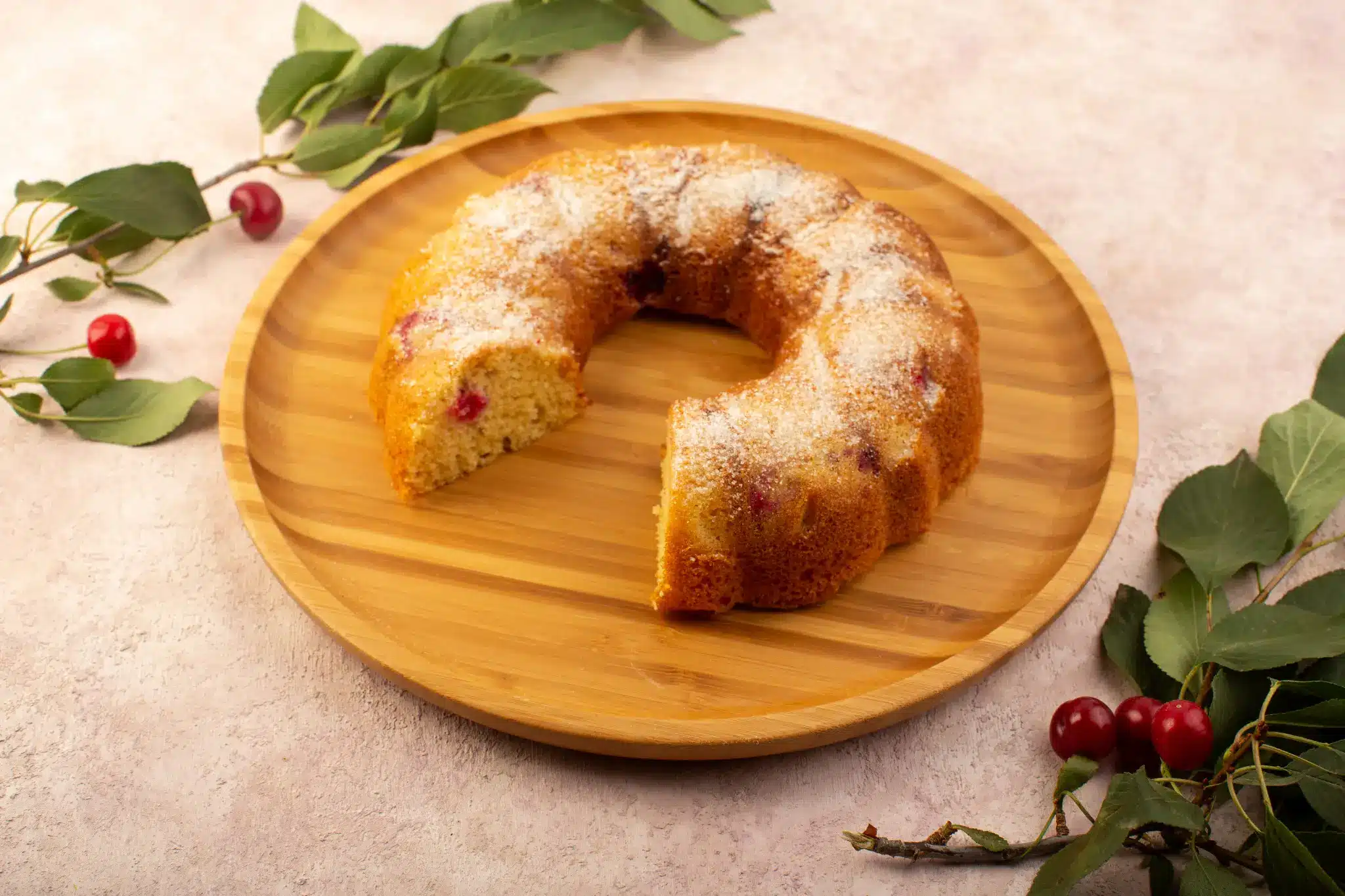 Bolo de fubá escaldado, servido em prato de madeira."