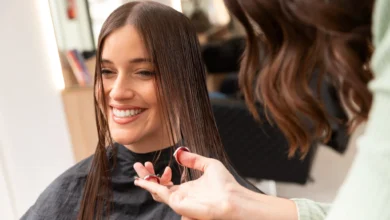 Mulher sorrindo enquanto faz um corte para dar volume aos cabelos.