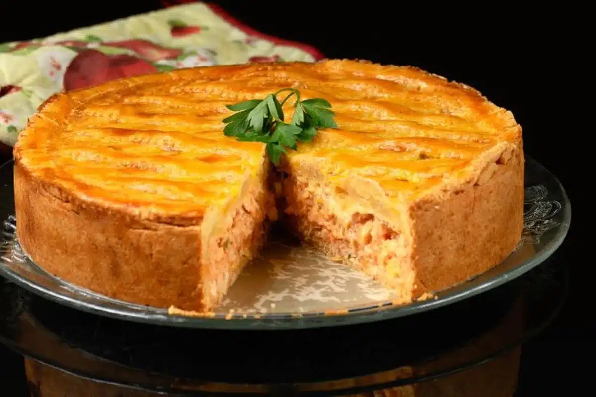 Torta de frango com massa crocante e recheio cremoso, ideal para um lanche saboroso.
