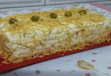 Torta fria de frango e pão decorada com batata palha e azeitonas