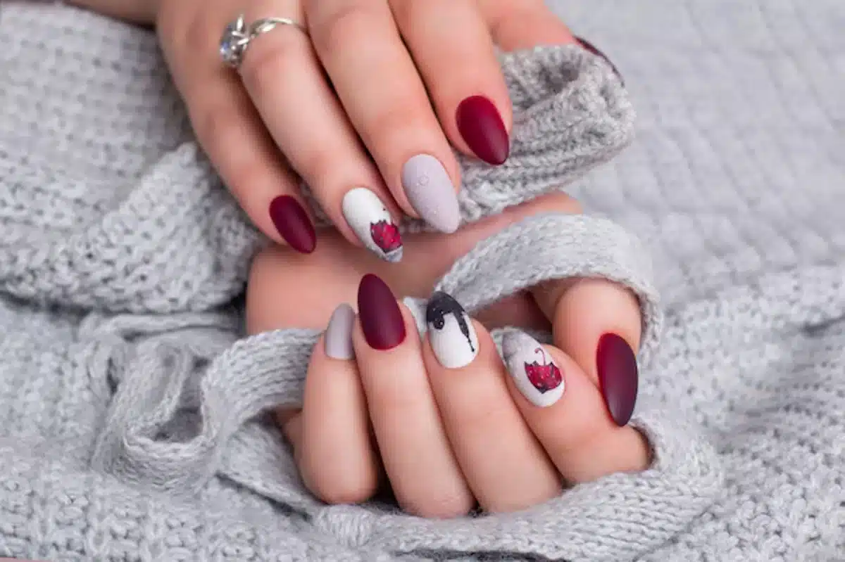 Unhas arredondadas com design artístico, seguindo as tendências para mulheres 50+.