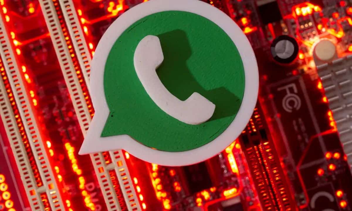 : "Logo do WhatsApp sobre fundo com luzes vermelhas, informando que o aplicativo vai parar de funcionar em abril em certos celulares