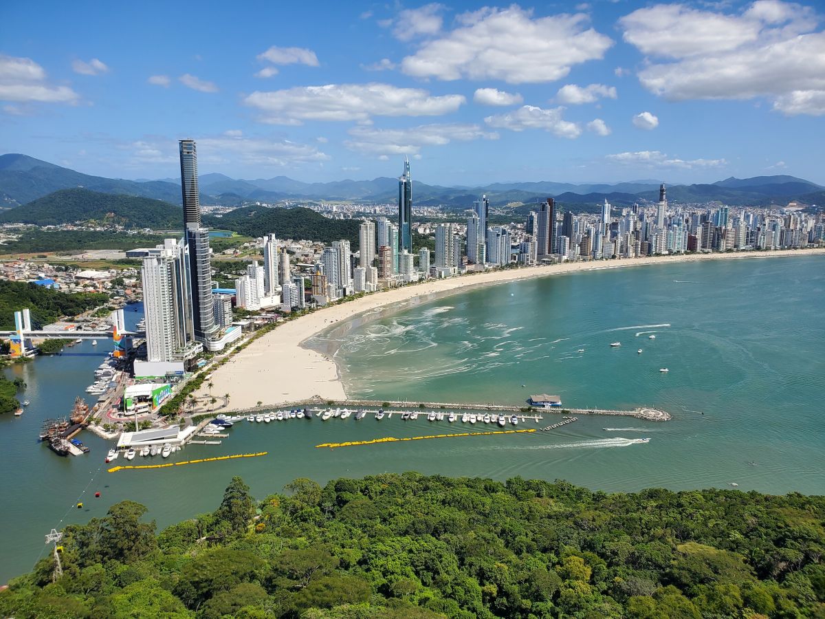 Vista panorâmica de Balneário Camboriú com o mar e os edifícios à beira-mar, capturada do Parque Unipraias