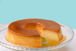  Pudim de leite caseiro com fatia retirada, servido com calda de caramelo