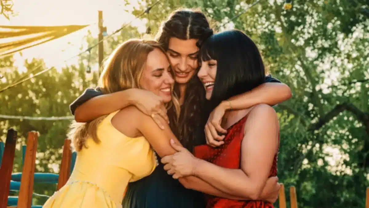 Três amigas se abraçando ao ar livre, representando o poder da amizade e superação, em uma série turca que fala sobre alma ferida
